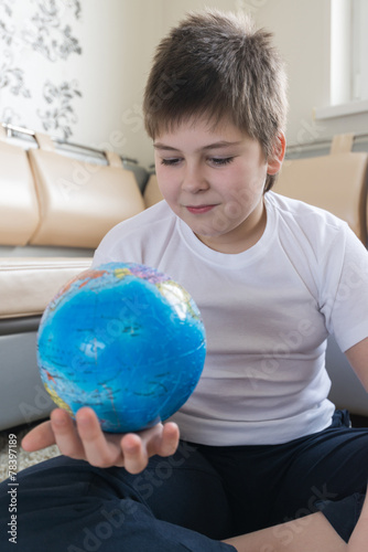 Boy studying globe in the room