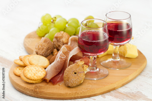 red wine with dry fruits, cookies and cheese