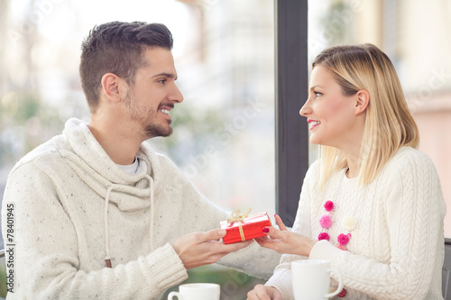 Romantic young man giving present to his girlfriend
