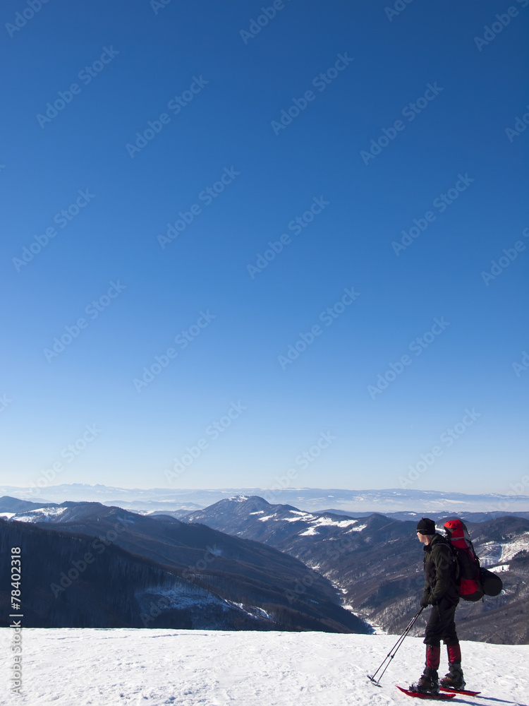 The man in snowshoes in the mountains.