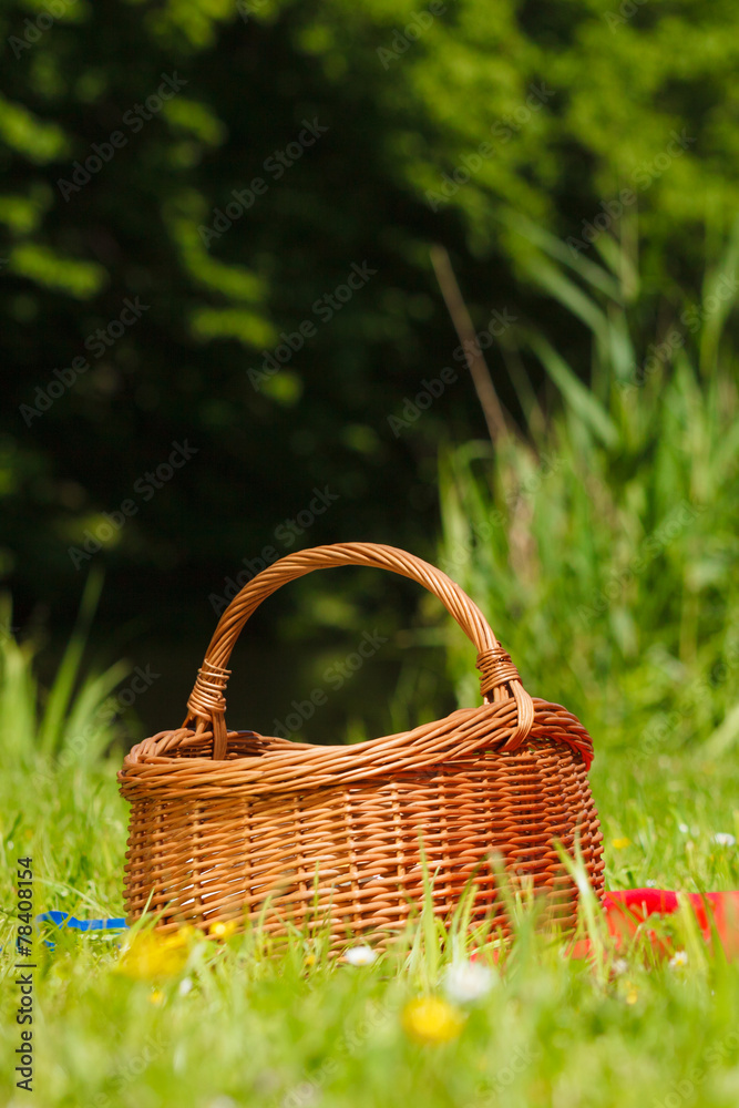 picnic basket on meadow in green grass picnic basket on meadow in green grass