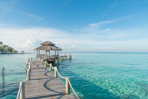 Tropical hut and wooden bridge at holiday resort. Summer travel