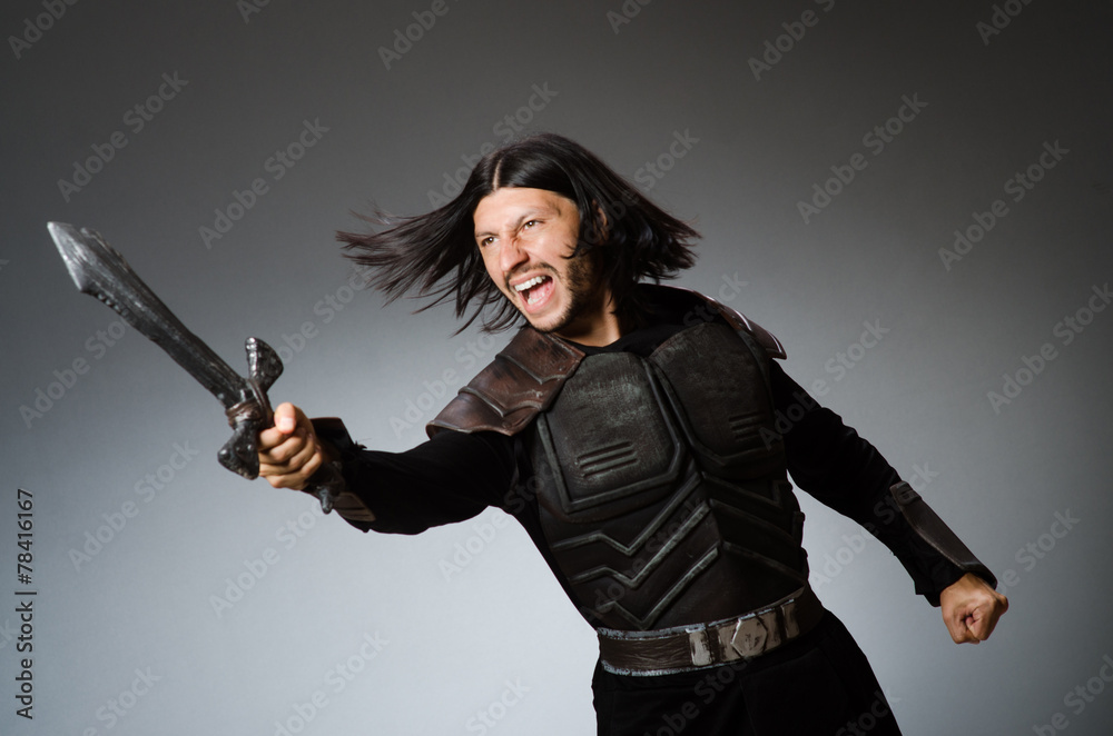 Angry knight with sword against dark background Angry knight with sword against dark background