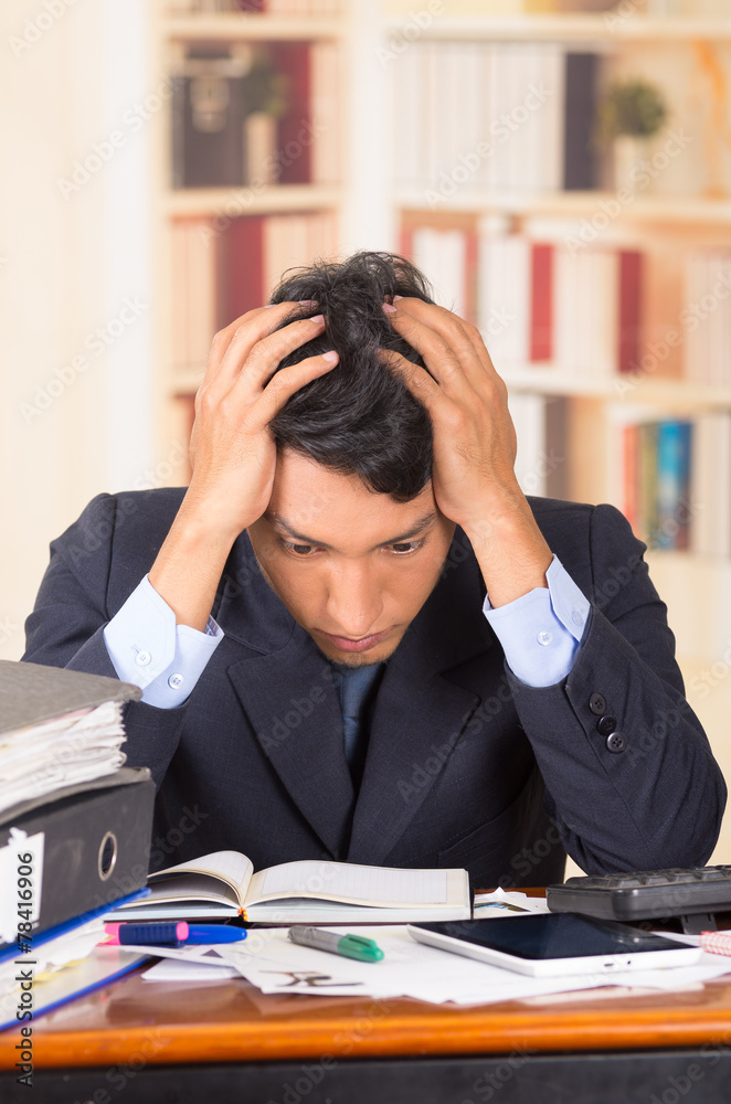young stressed overwhelmed man with piles of folders on his desk young stressed overwhelmed man with piles of folders on his desk
