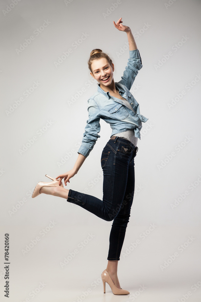 Obraz premium Smiling student girl with one leg and hand up