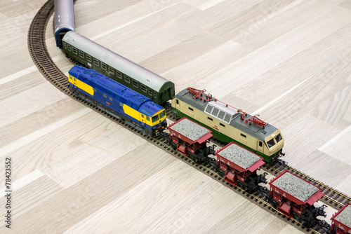 Two model trains on wooden floor, game for kids