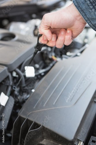 Man using dipstick to check oil