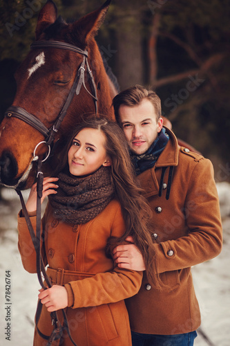 outdoor fashion portrait of young sensual couple and horse