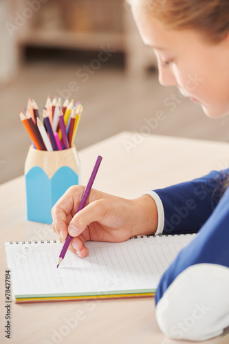 Close up of schoolgirl writing in her notebook