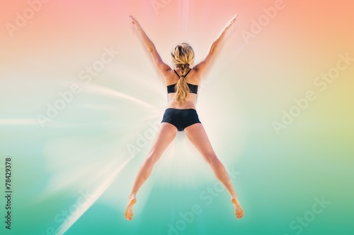 Composite image of fit blonde jumping with arms outstretched