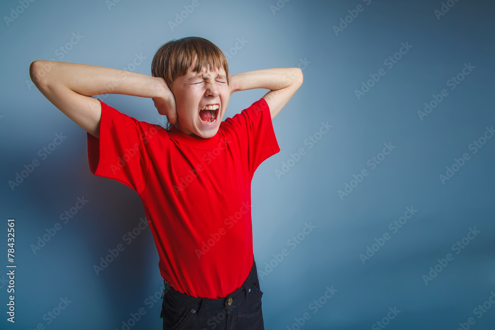 Fototapeta premium boy teenager European appearance in a red shirt covered his ears