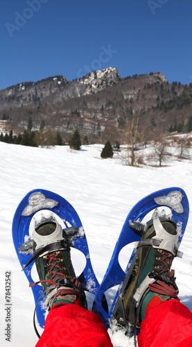 man with blue modern snowshoes in the mountain