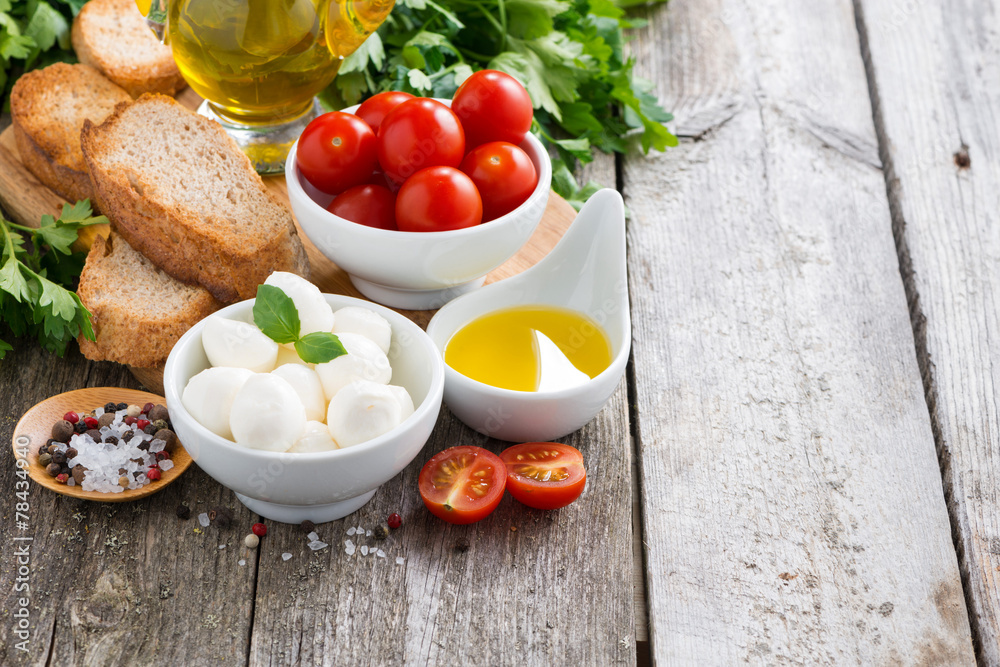 mozzarella and ingredients for the salad on a wooden background mozzarella and ingredients for the salad on a wooden background