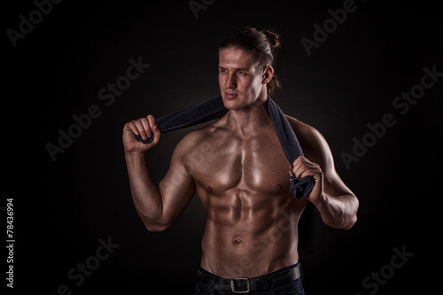 Young man after training on dark background