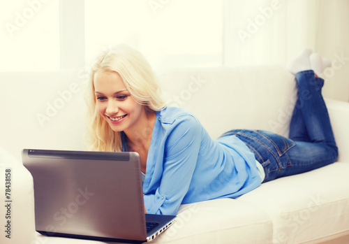 smiling woman with laptop computer at home © Syda Productions