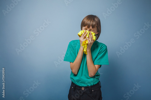 European-looking boy of ten years is ill, a handkerchief, a runn photo