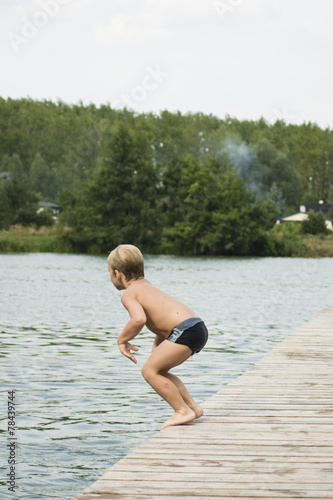 chłopiec skacze do wody