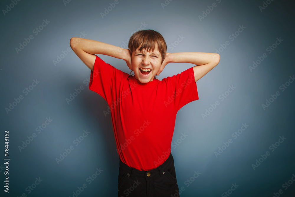Fototapeta premium boy teenager European appearance in a red shirt covered his ears