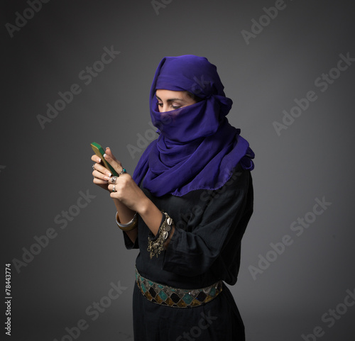 islamic woman messaging with phone photo