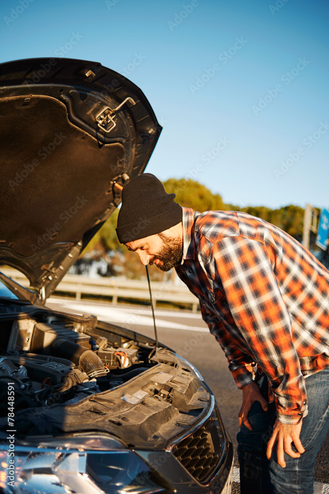 Man looking at broken old new rental car vehicle engine and try