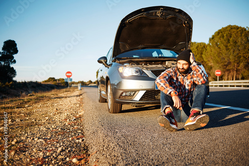 Obraz na plátne Car and driver man in beautiful sunny landscape. Portrait of sad