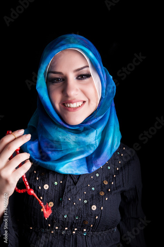 beautiful muslim woman wearing hijab praying on rosary / tespih