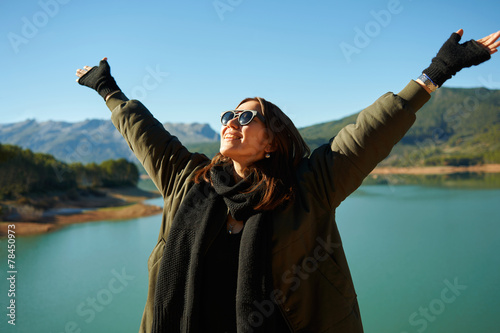 Happy smiling asian woman cheering outdoors under the blue sky. photo