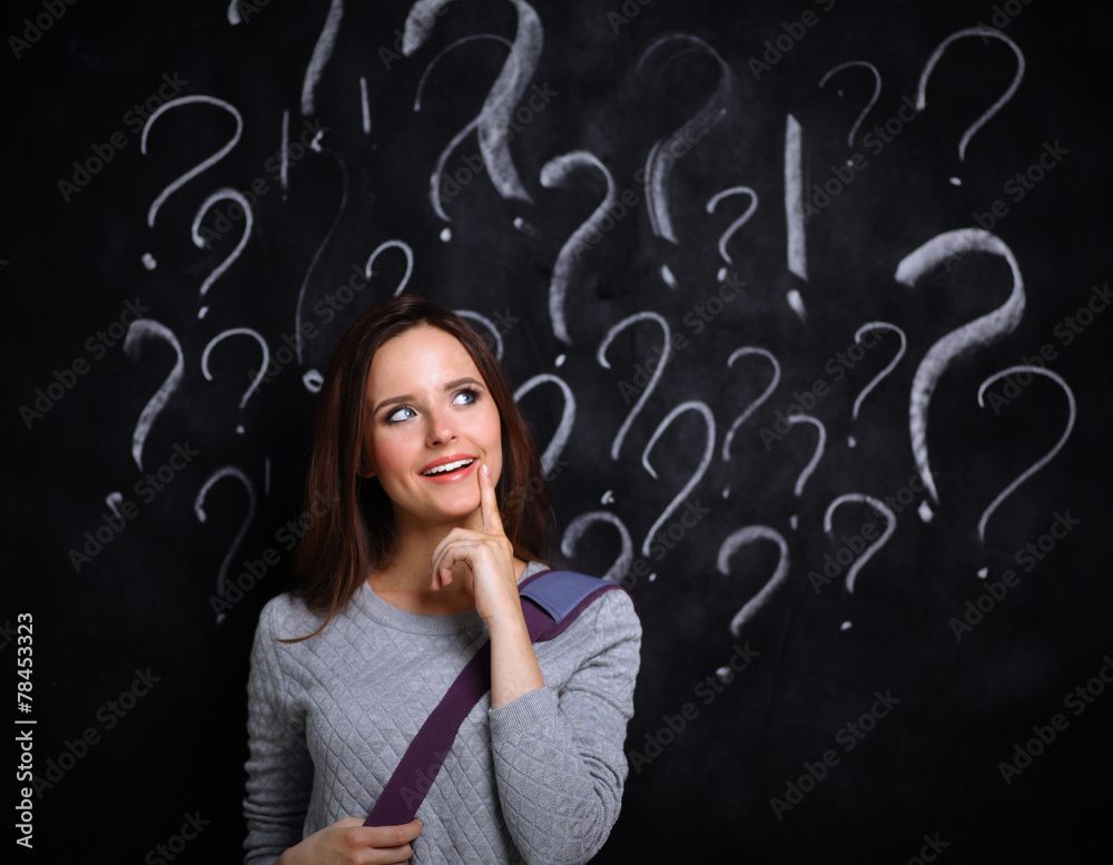 Young girl with question mark on a gray background Young girl with question mark on a gray background