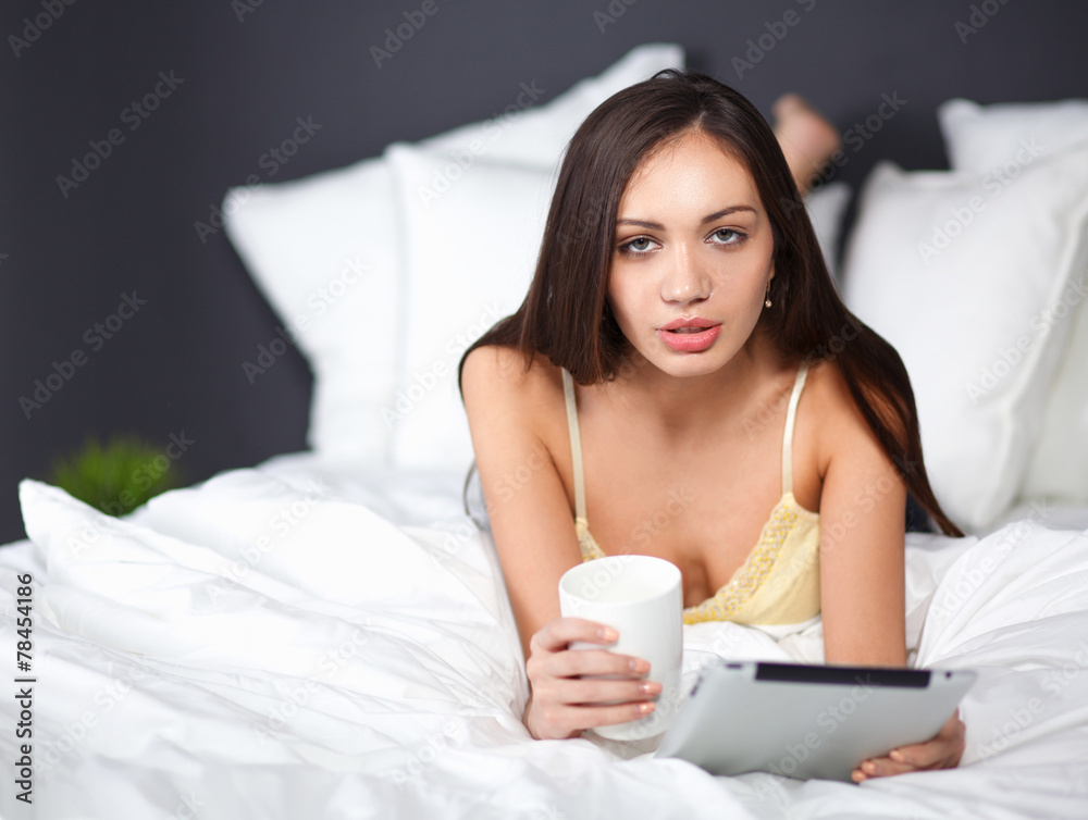 Women use a tablet pc on the bed