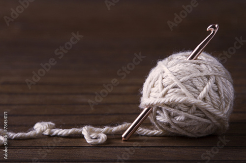 Photo Ball of cream yarn with crochet hook