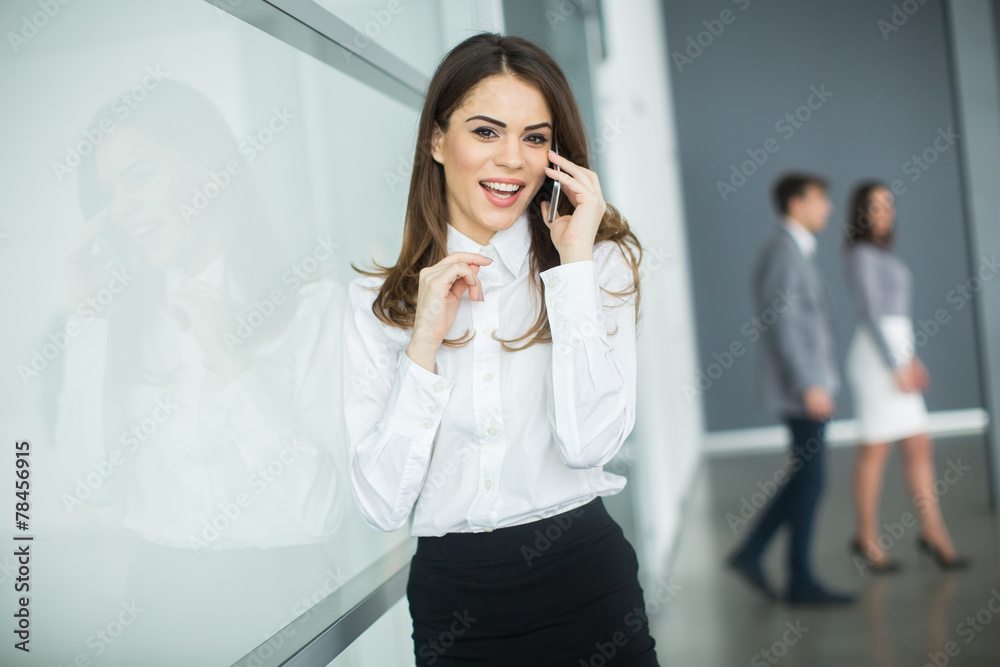 Young woman in office with mobile phone Young woman in office with mobile phone