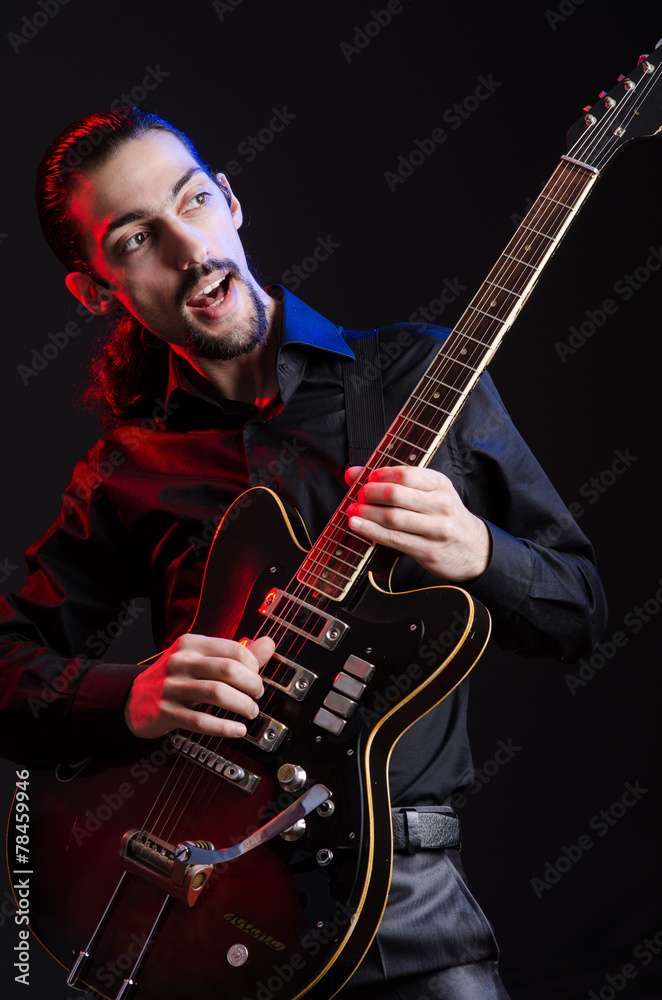 Obraz premium Man with guitar during concert