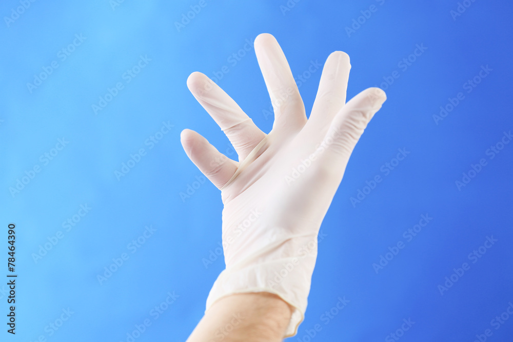 Doctor hand in sterile gloves on blue background Doctor hand in sterile gloves on blue background