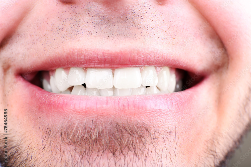Naklejka premium Smiling man after visit dentist om blurred background, macro