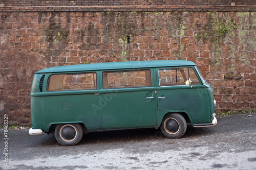 Green van parked near an ancient wall in Rome, Italy