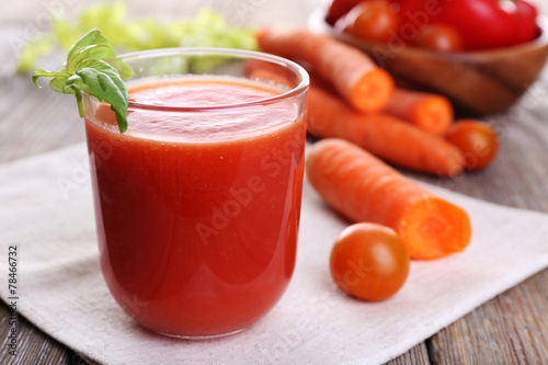 Glass of tomato juice with vegetables on wooden table close up