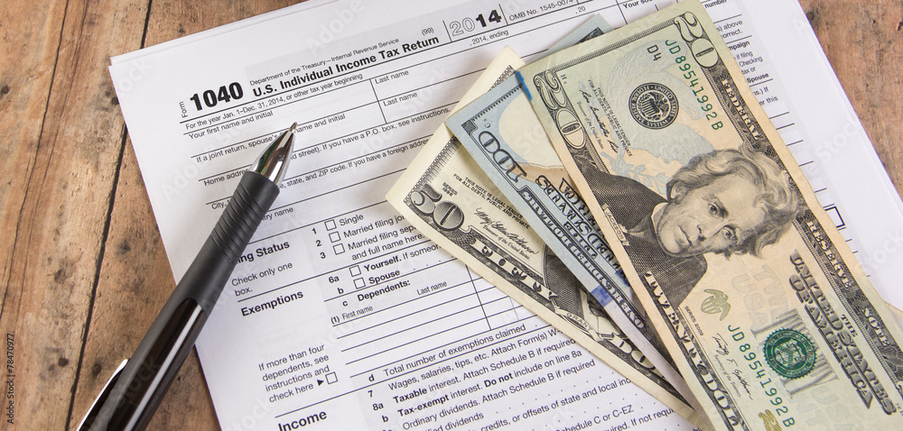 1040 tax form with calculator and dollar bills 1040 tax form with calculator and dollar bills
