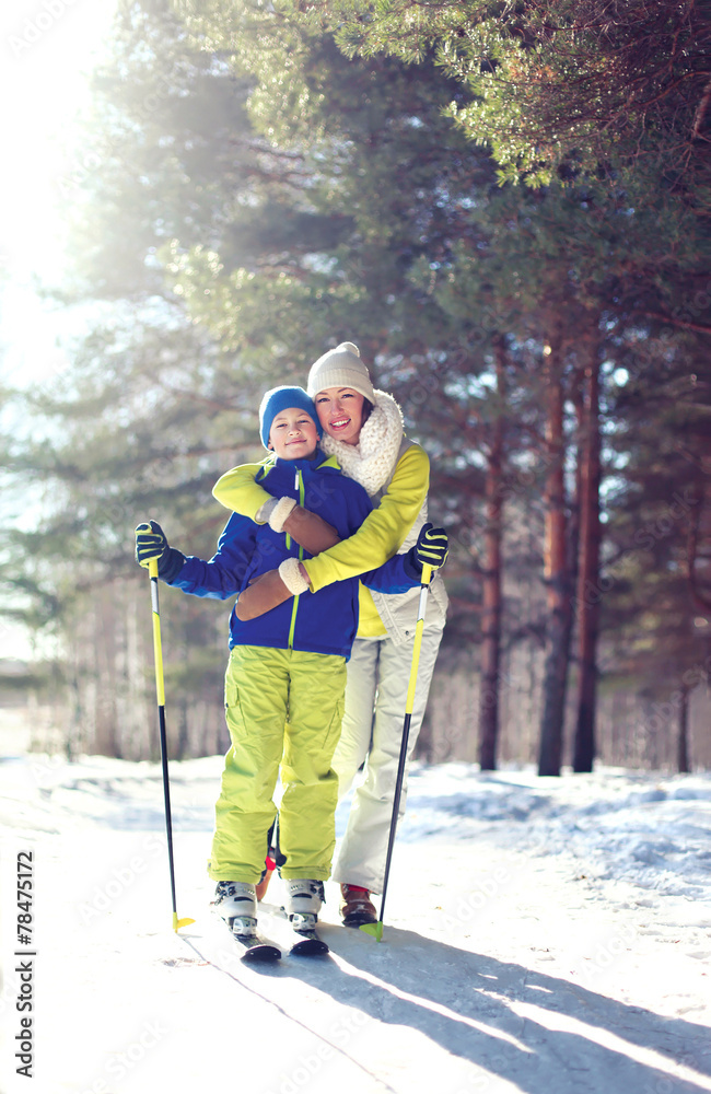 Family healthy lifestyle! Mother and son go skiing in the woods