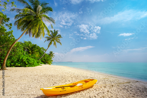 Kayak on sunny tropical beach with palm trees on Maldives