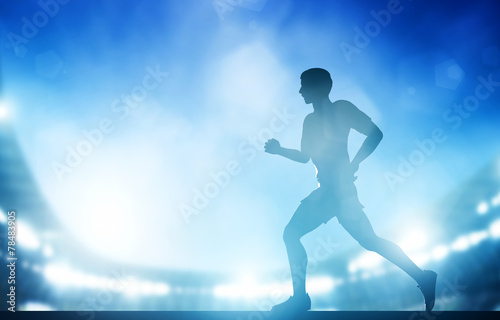 Man running on the stadium in night lights. Athletics run