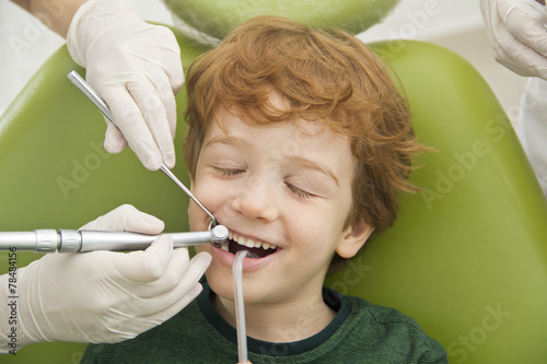 close up of boy having his teeth examined by dentist