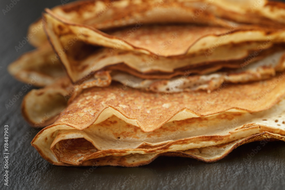 thin crepes or blinis folded in triangles on slate board thin crepes or blinis folded in triangles on slate board