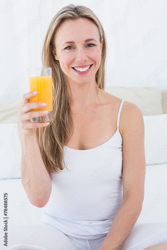 Smiling blonde holding glass of orange juice Smiling blonde holding glass of orange juice