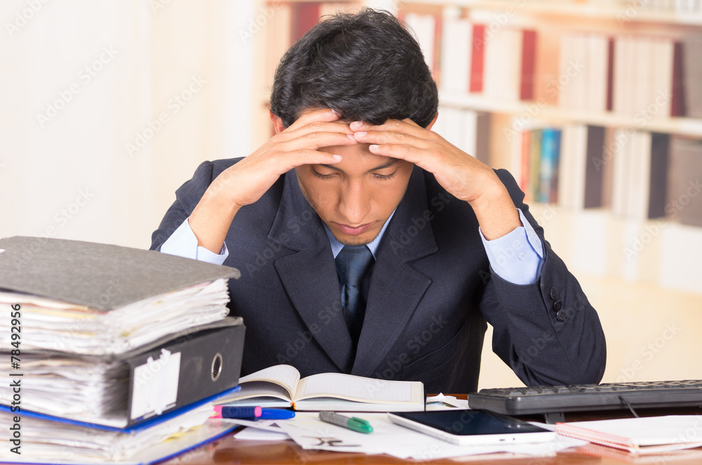 young stressed overwhelmed man with piles of folders on his desk young stressed overwhelmed man with piles of folders on his desk