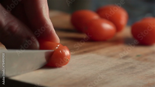 Slow motion of little tomatoes slicing. Find similar in our port