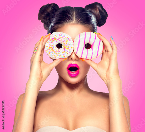 Beauty model girl taking colorful donuts. Dieting concept