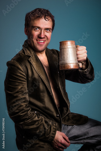 The man holding mug in his hand and watching at the camera