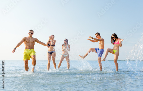 happy friends having fun on summer beach