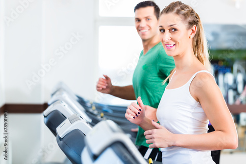 Mann und Frau auf Stepper im Fitnessstudio