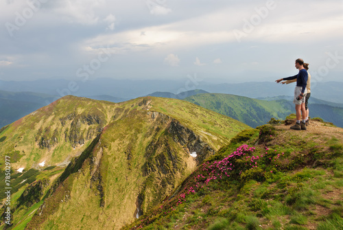 Trekker walking flowers field in mountain